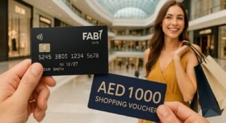 A person holds a sleek black FAB Elite Credit Card and an AED 1,000 shopping voucher in the foreground, while in the blurred background, a smiling woman in a mustard dress carries shopping bags inside a modern, upscale shopping mall.