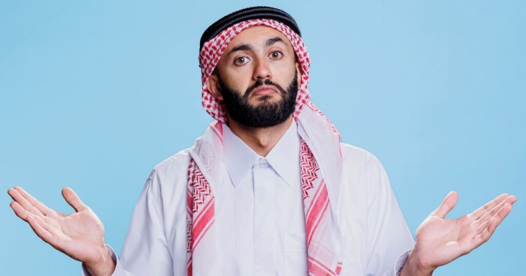 Confused Middle Eastern man in traditional keffiyeh and white kandura shrugging with hands raised, expressing uncertainty about credit card decisions or financial mistakes in the UAE